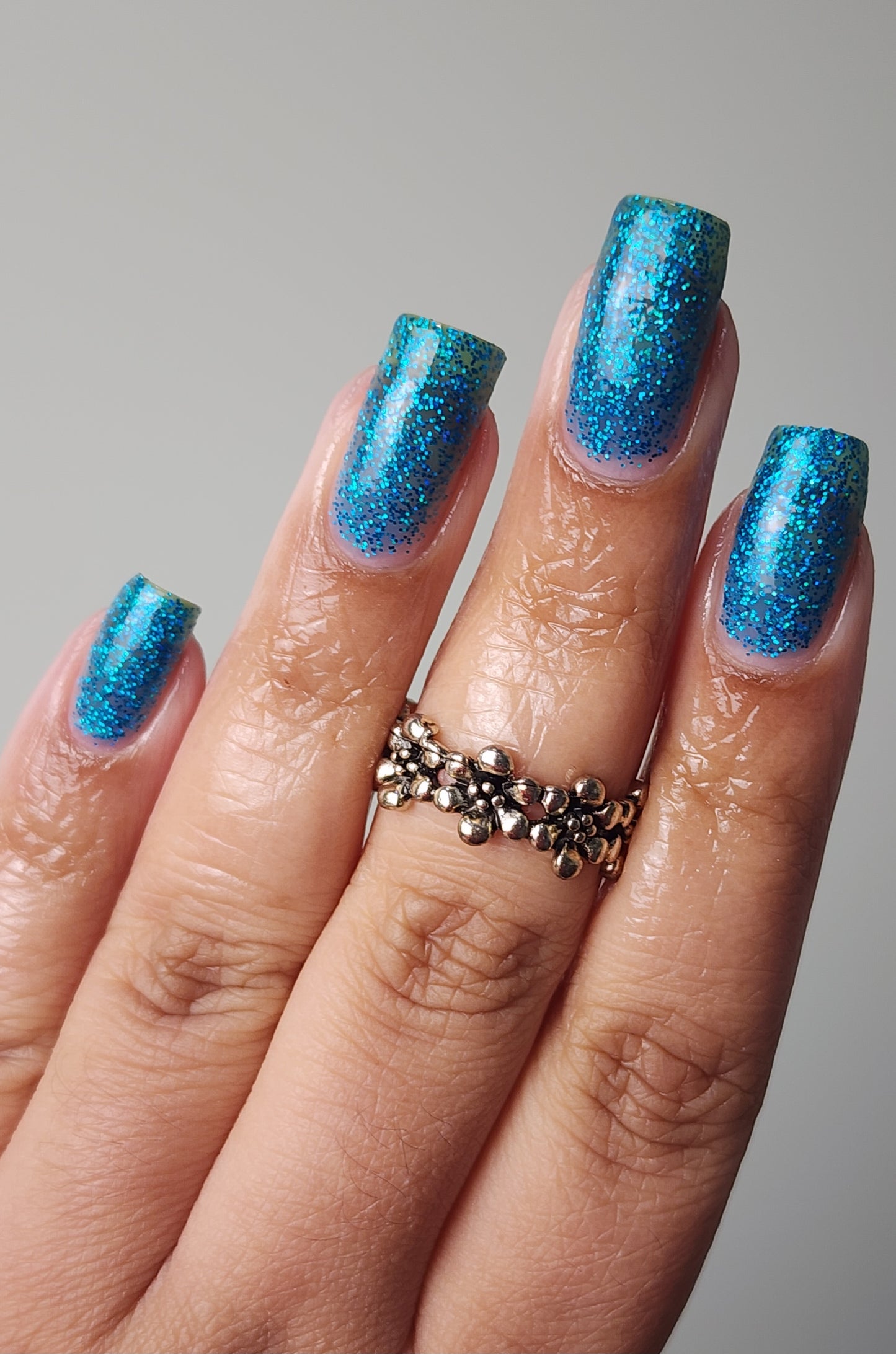 Sparkling blue glitter nail polish inspired by holiday magic, from the Screen and Sparkles collection.