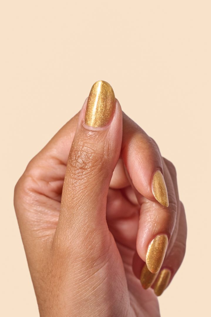 Radiant gold glitter nail polish with eco-friendly sparkle, inspired by Caribbean celebration, from the Masquerade Collection.