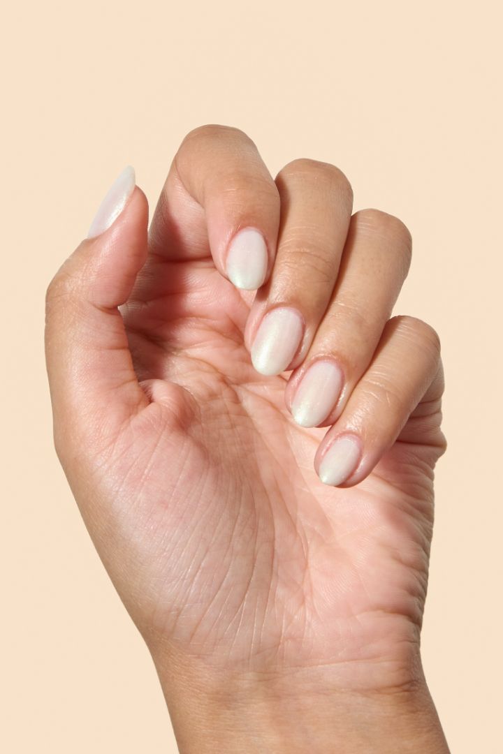 White shimmer nail polish with a soft gold glow from the Screen and Sparkles collection