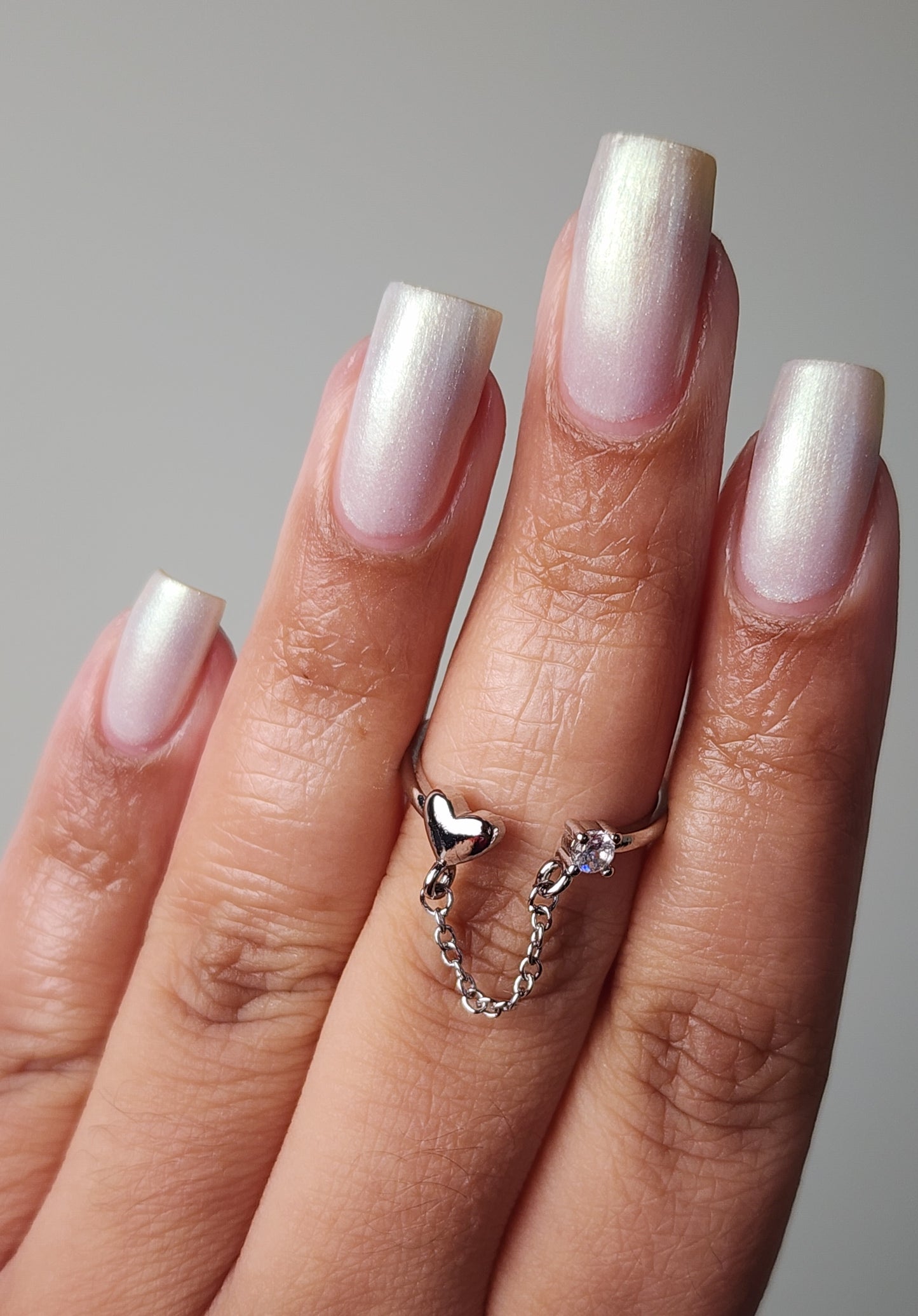 White shimmer nail polish with a soft gold glow from the Screen and Sparkles collection.