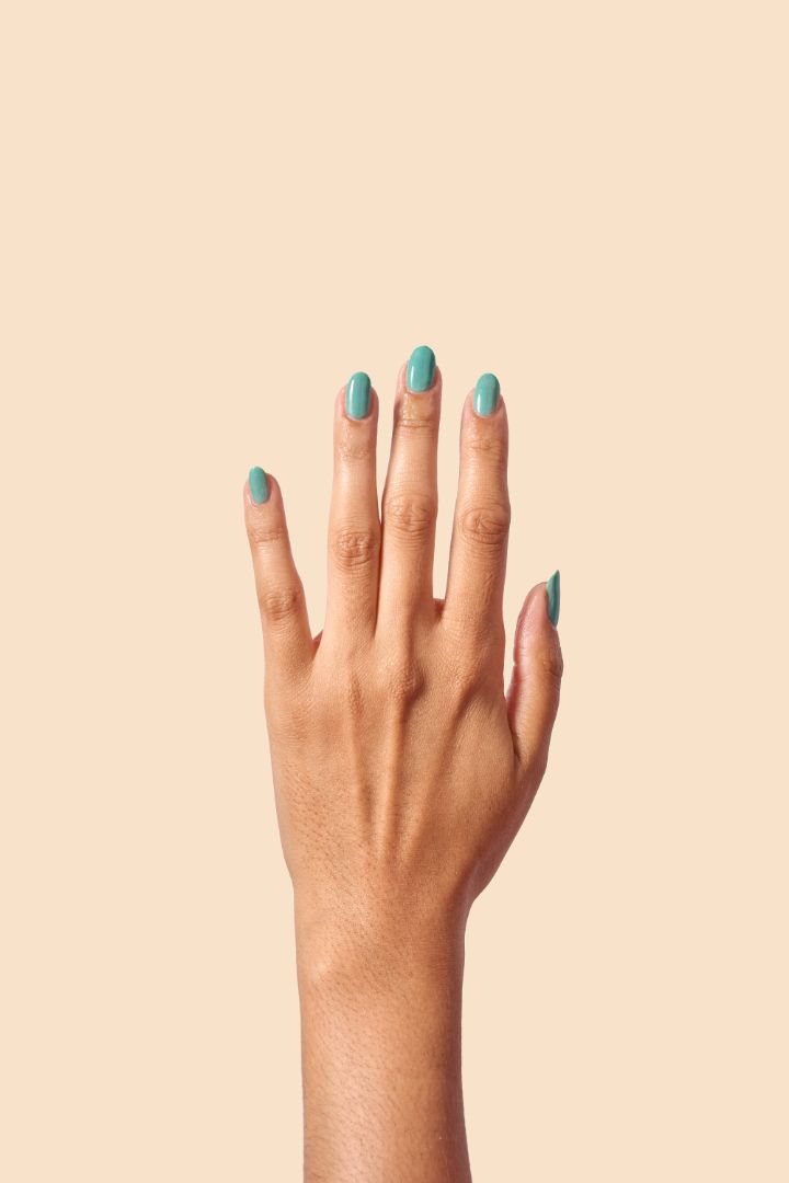 Teal glitter nail polish inspired by Caribbean J’ouvert celebrations, from the Masquerade Collection.