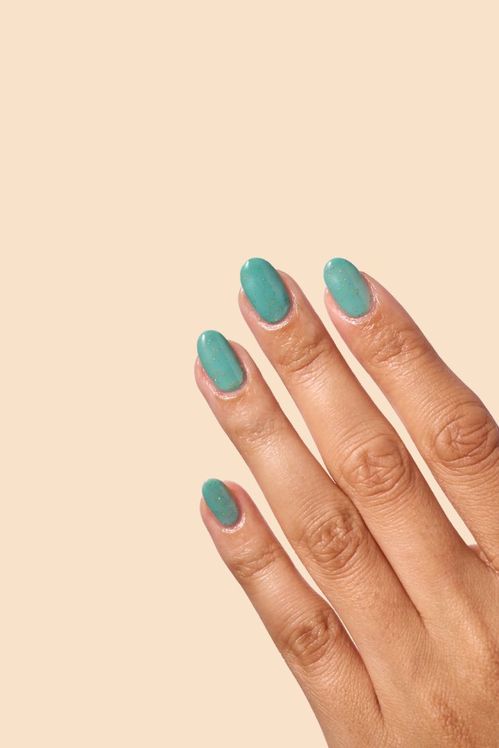 Teal glitter nail polish inspired by Caribbean J’ouvert celebrations, from the Masquerade Collection.