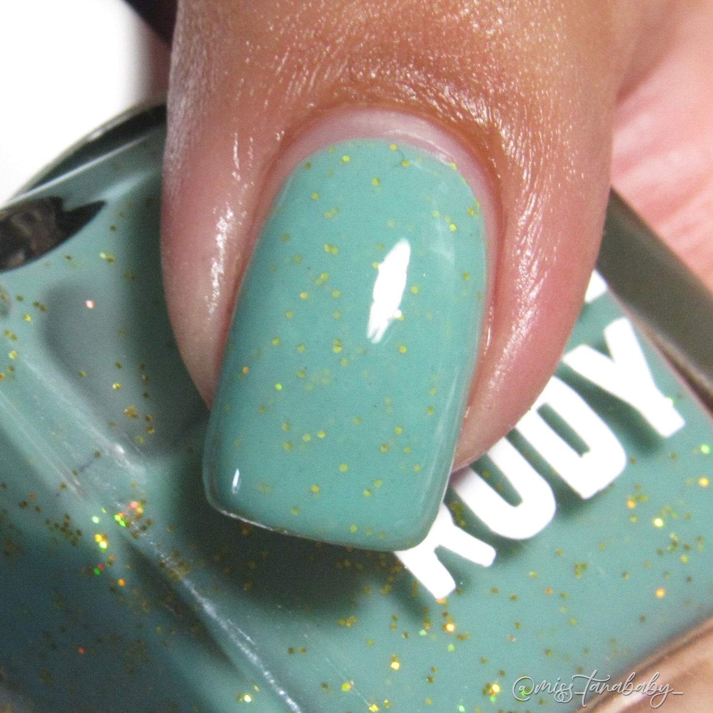 Teal glitter nail polish inspired by Caribbean J’ouvert celebrations, from the Masquerade Collection.