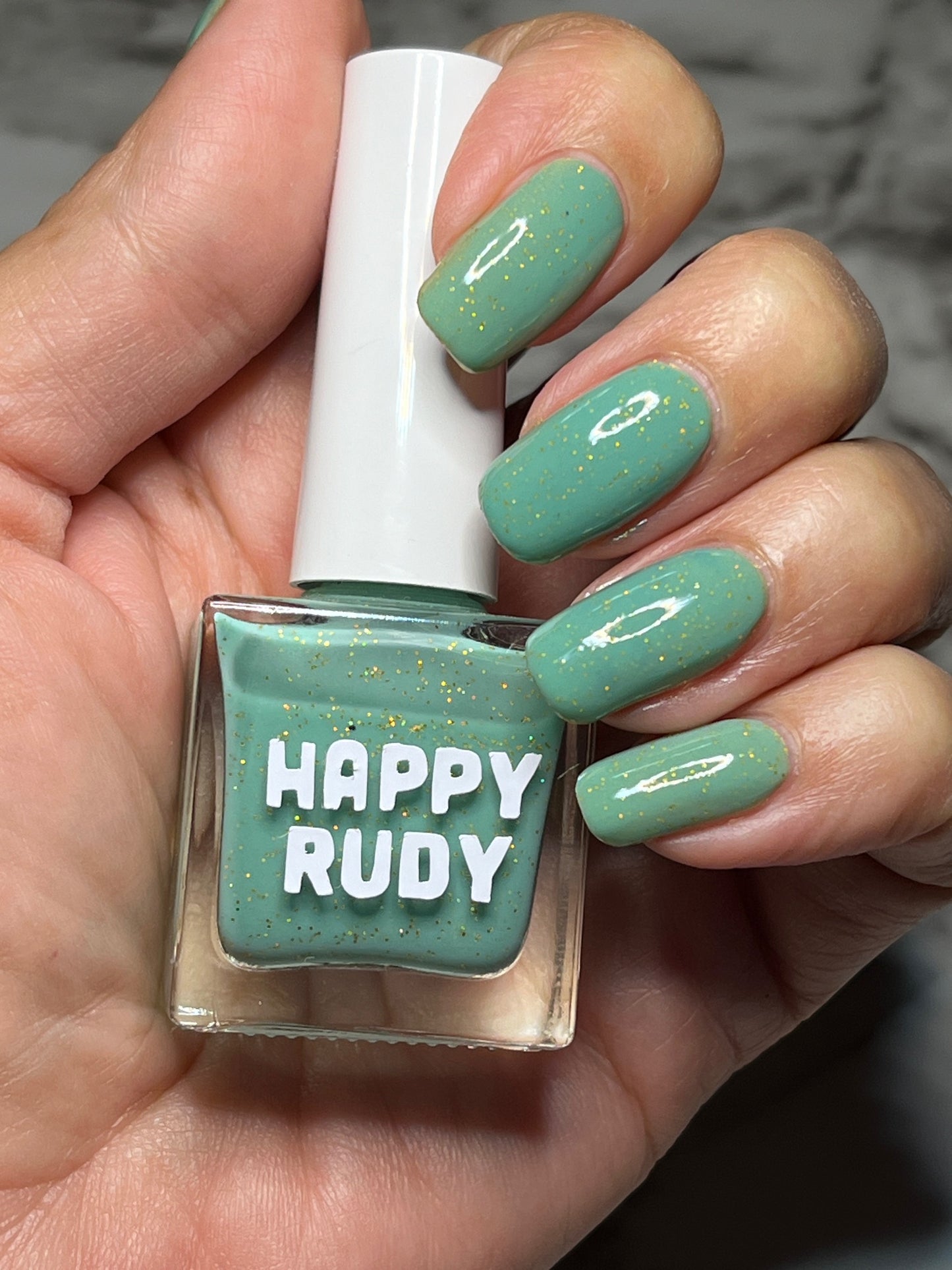 Teal glitter nail polish inspired by Caribbean J’ouvert celebrations, from the Masquerade Collection.