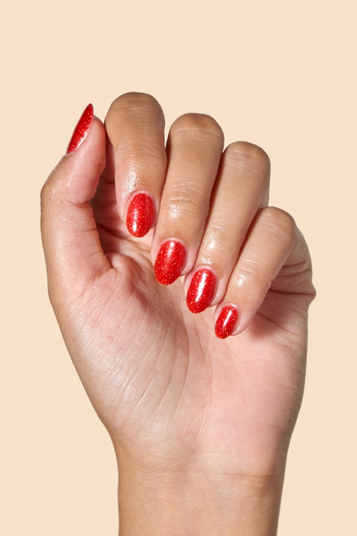 Bold ruby red glitter nail polish perfect for festive looks, part of the Screen and Sparkles collection.