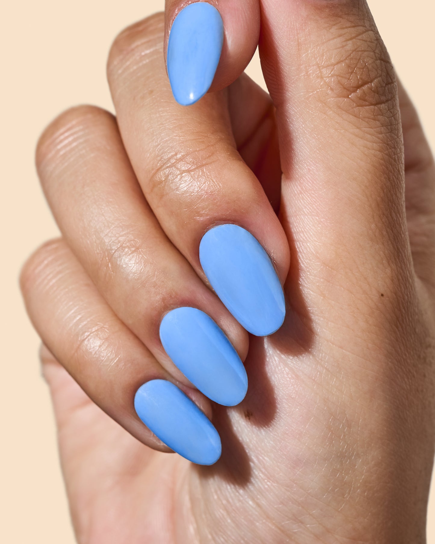 Bold cornflower blue crème nail polish for vibrant spring nails.
