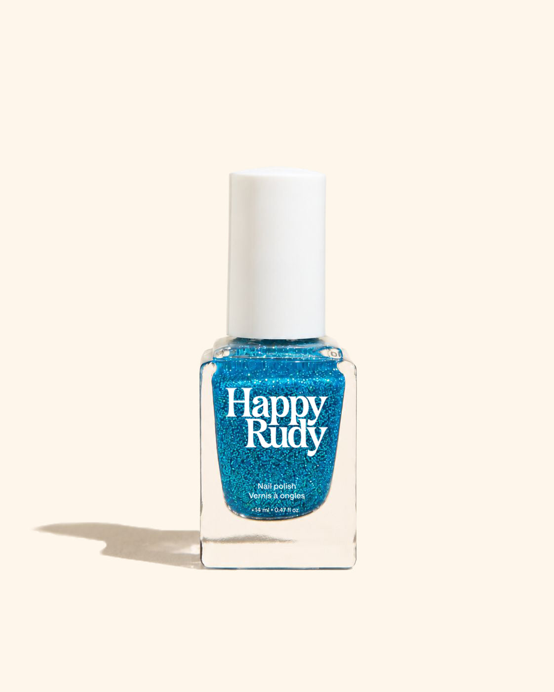 A bottle of Happy Rudy glitter nail polish in a vibrant blue shade, set against a solid cream background with a soft shadow.