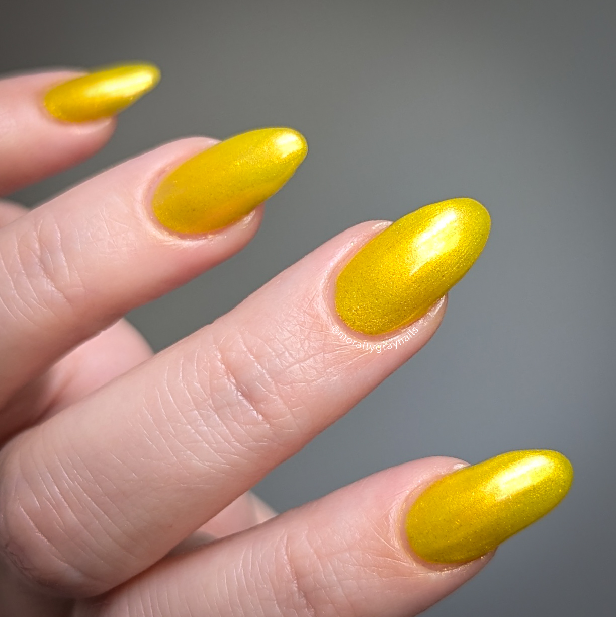 Four-On-The-Floor: a radiant yellow gold shimmer nail polish lacquer filled with eco-friendly glitter on a light skin tone