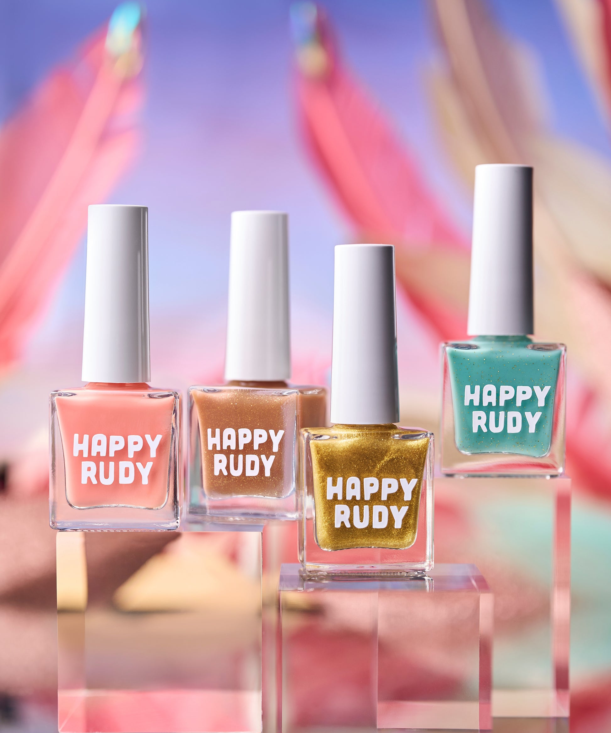 Four bottles of Happy Rudy nail polish with colorful blurred background