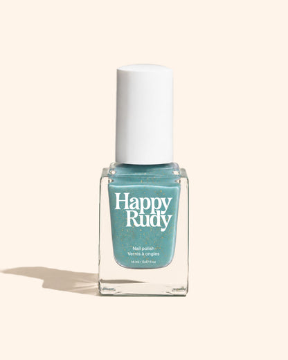 A bottle of Happy Rudy nail polish in a light blue-green shade with gold glitter, featuring a white cap and clear glass bottle, set against a solid pale beige background.