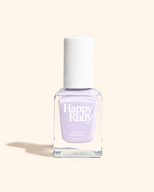 A bottle of Happy Rudy nail polish in a light lavender shade, featuring a white cap and a clear glass bottle, set against a solid cream background.