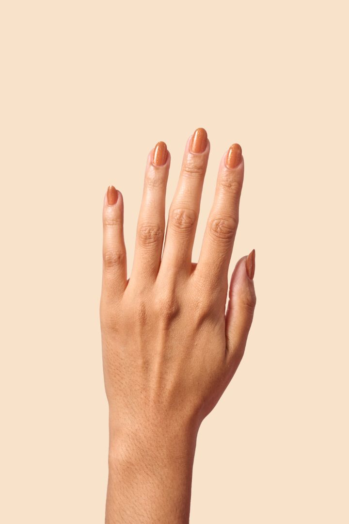 Caramel brown nail polish with gold eco-friendly glitter from the Masquerade Collection.
